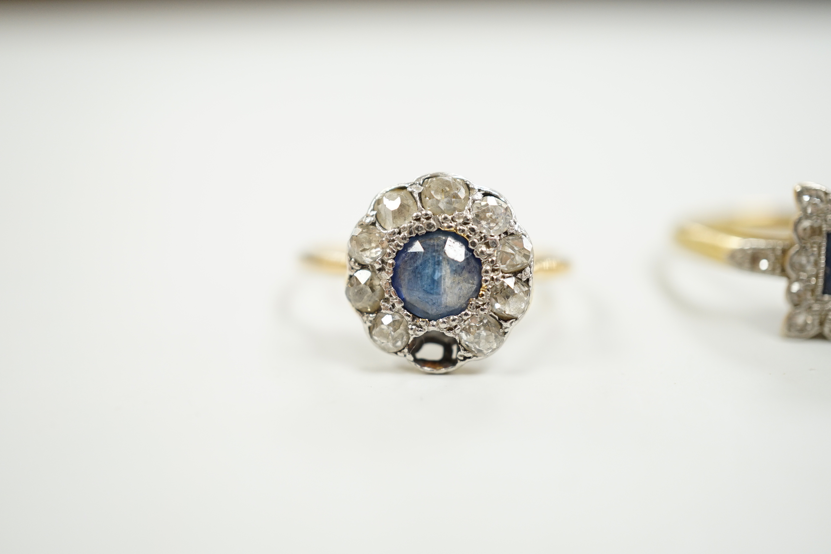 Two 1920's 18ct, sapphire and diamond cluster set dress rings, (one with misshapen shank and missing a diamond), gross weight 6.1 grams.